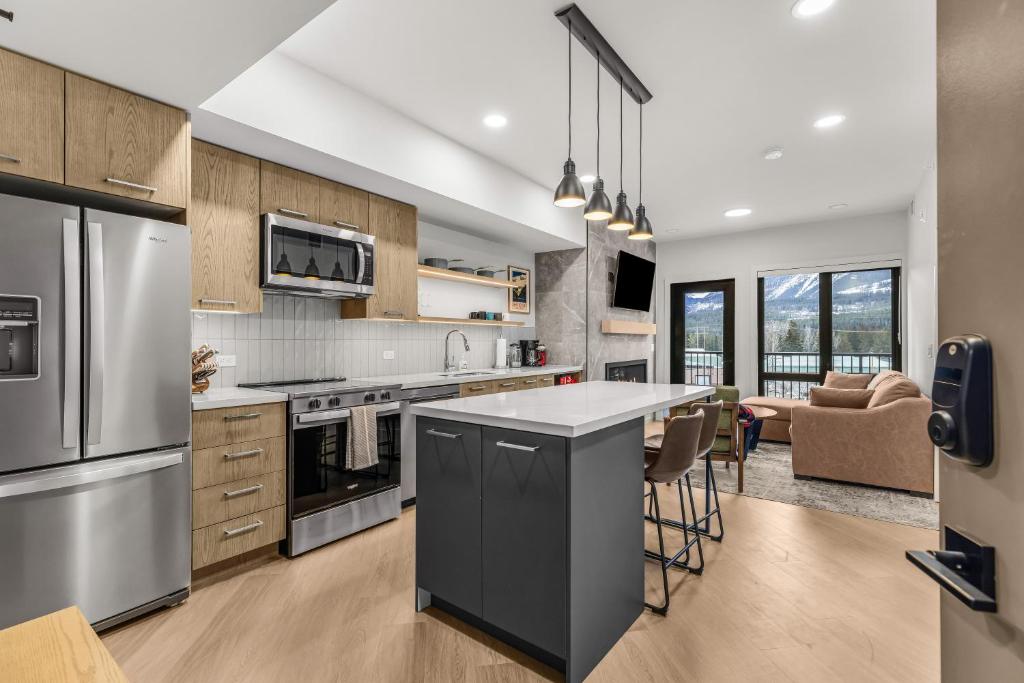 a kitchen with stainless steel appliances and a counter top at Modern mountain luxury with stunning views in Canmore