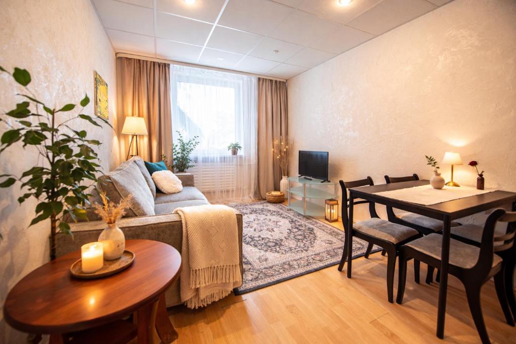 a living room with a table and a dining room at Patricia Apartments in Vilnius