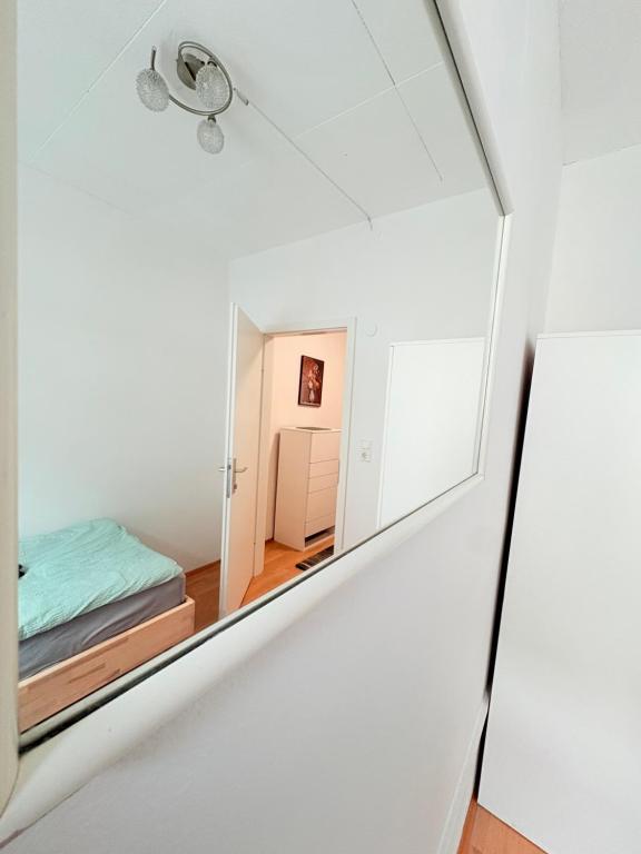 a mirror in a white room with a bed at Beenie 18 in Linz