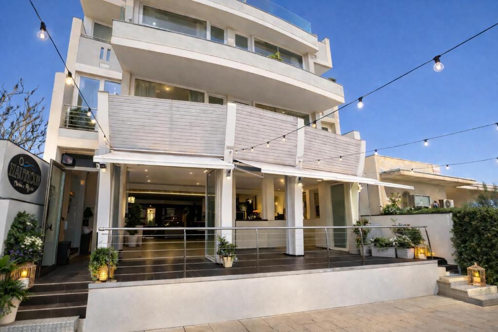 a large white building with stairs in front of it at Nauticus Hotel Ugento in Torre San Giovanni Ugento