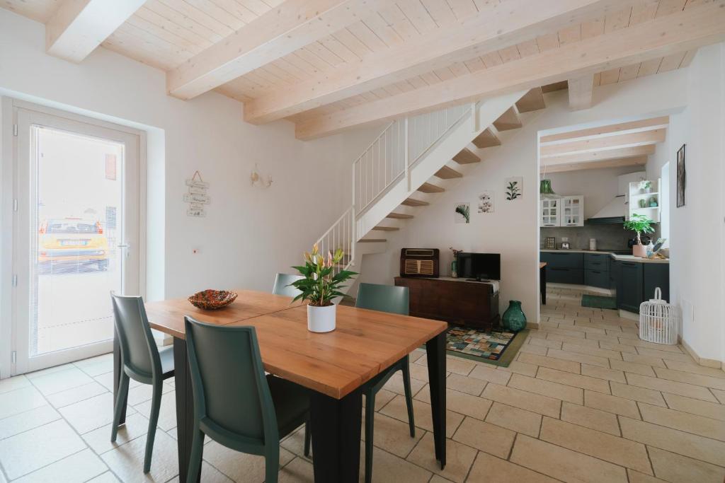 a dining room with a wooden table and green chairs at Il Conventino 46 in Falconara Marittima