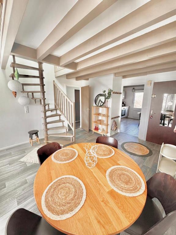 a dining room with a wooden table and chairs at Duplex à proximité de la place Stanislas in Heillecourt