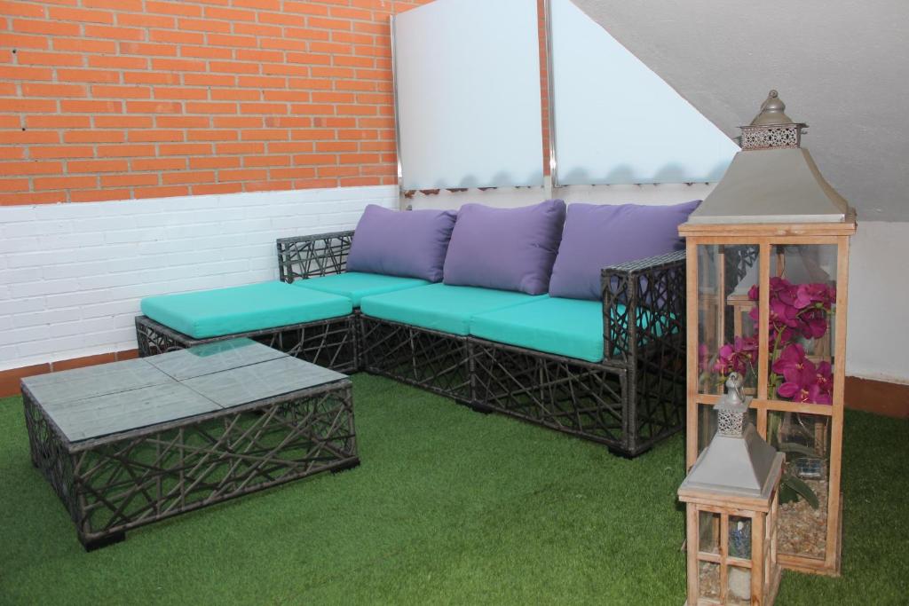 a patio with a couch and a table and a clock at LA OKIYA DE TATI in Zamora