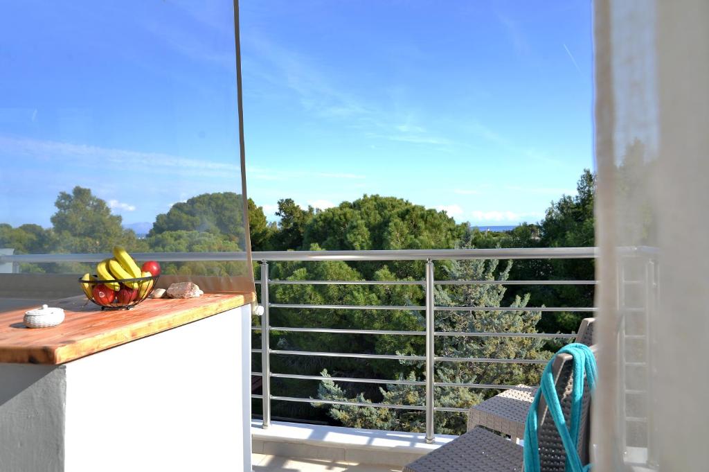 a view from a balcony with a table and a bowl of fruit at SunDay Free Airport Shuttle in Artemida