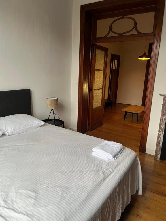 a bedroom with a white bed and a wooden floor at Brussels EU District Mansion in Brussels