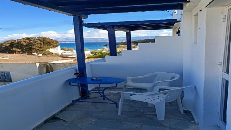 Ein Tisch und Stühle auf einem Balkon mit Blick auf das Meer in der Unterkunft Molos Pine view in Molos Parou