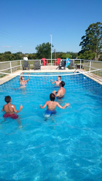 a group of people swimming in a swimming pool at El Tajamar in Fray Bentos