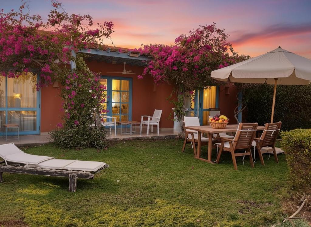 a patio with a table and chairs and an umbrella at Unique cozy villa sea view in Hurghada