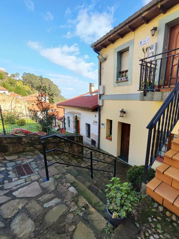 a house with a balcony and a stone courtyard at Cau La Mar in Lastres