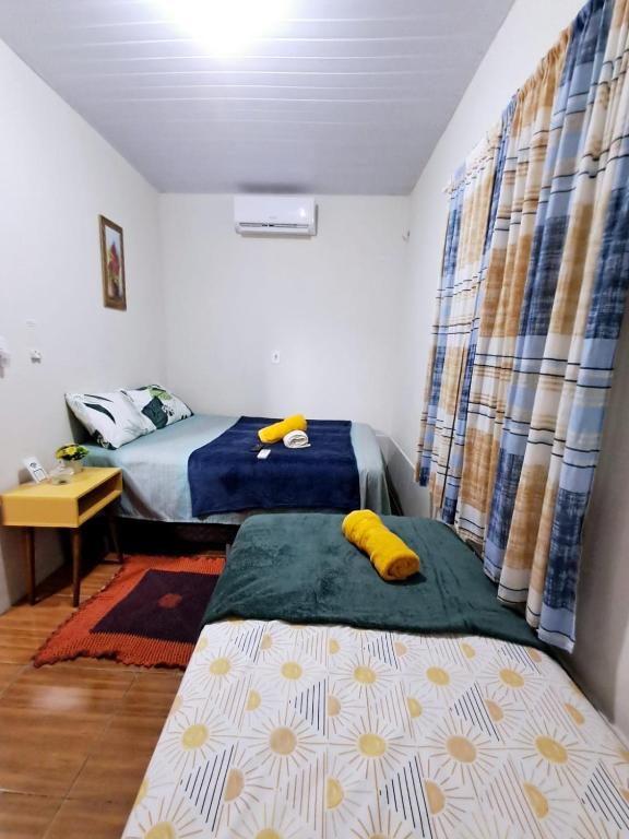 a bedroom with two beds and a desk and curtains at aguapé 1 in Barreirinhas