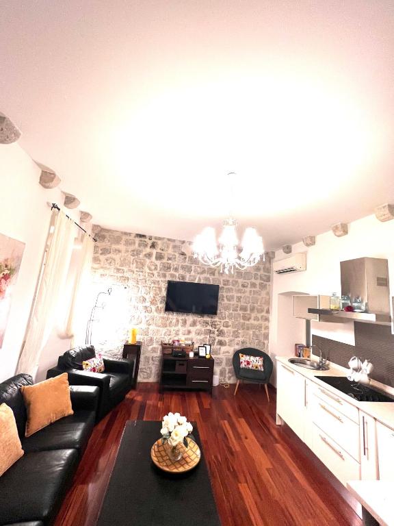 a living room with a black couch and a brick wall at 22 THE STRADUN in Dubrovnik