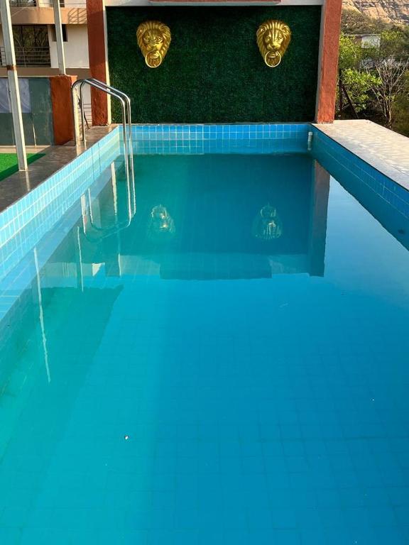 a blue swimming pool with two turtles in the water at Vedanta Retreat in Igatpuri