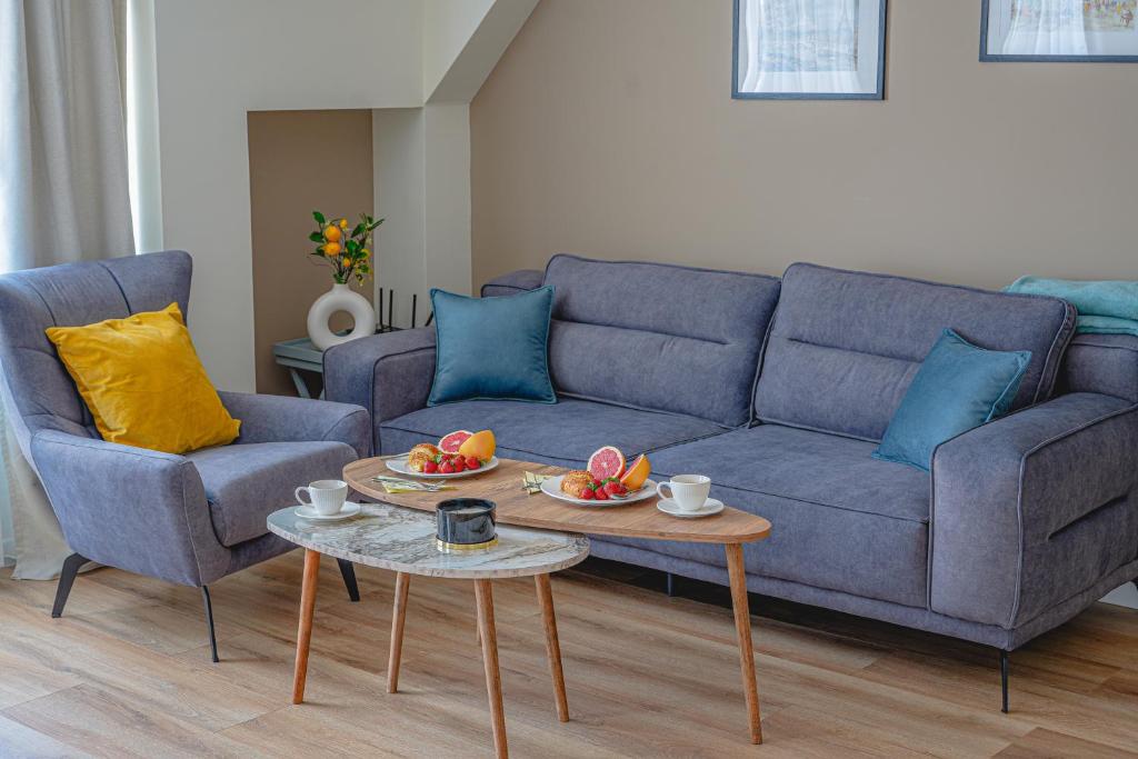 a living room with a blue couch and two chairs at Casa Frutta in Petrich