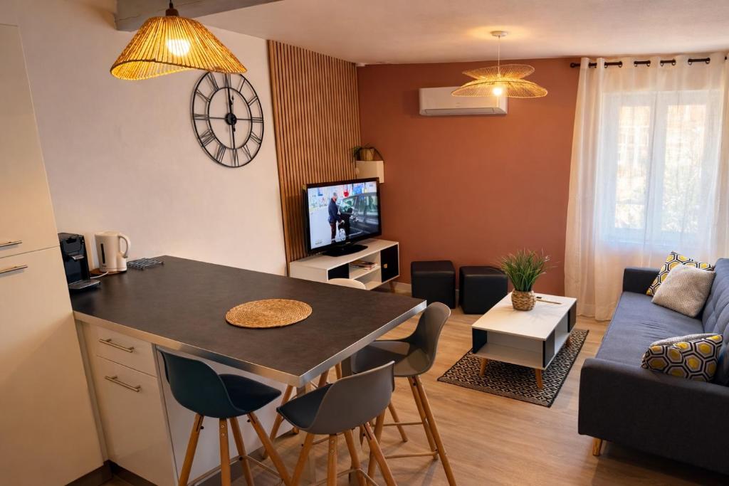 a kitchen and living room with a table and a couch at Duplex 2 chambres Meximieux centre ville in Meximieux