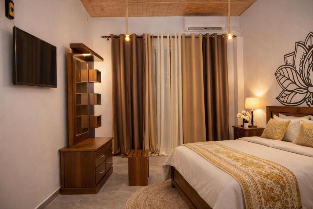 a bedroom with a bed and a television in it at Ocean Green Villa in Matara