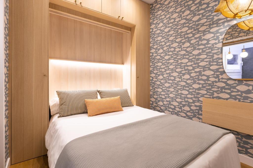 a bedroom with a bed and a wall at SEBASTIAN Apartamentos in Getaria