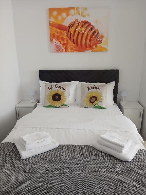 a bedroom with a white bed with two towels on it at Sun Studio Onești in Onești