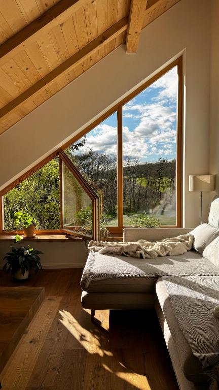 a bedroom with a bed and a large window at Hiša PRI JEZERU in Dobrovnik
