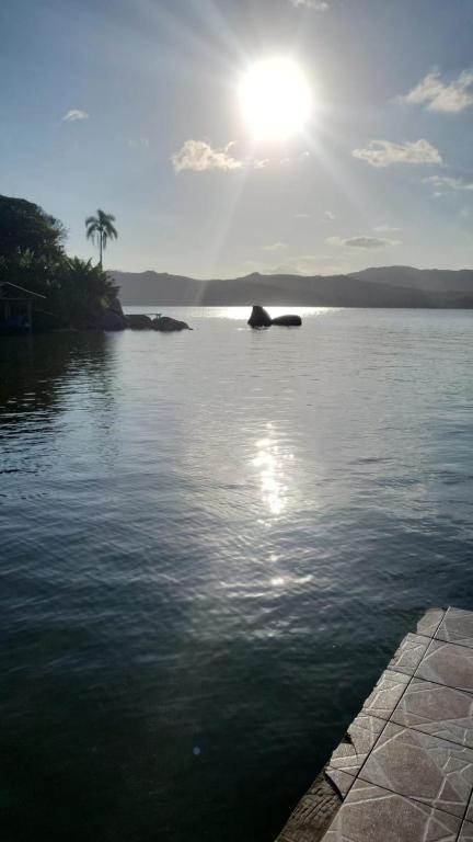a large body of water with the sun in the sky at paraiso da lagoa in Imbituba