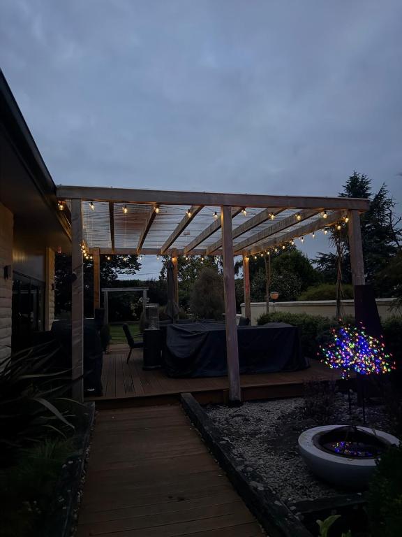 a wooden pergola with lights on a patio at Rakanui Hidden Retreat in Hilderthorpe