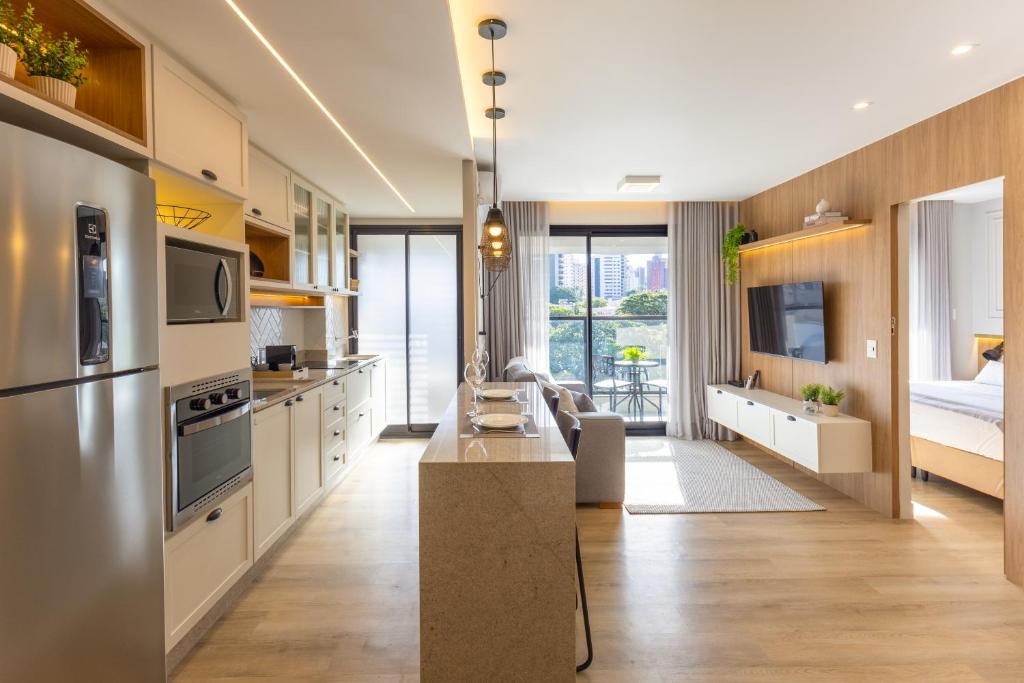 a kitchen with white cabinets and stainless steel appliances at Elegante Apartamento no Cambuí in Campinas