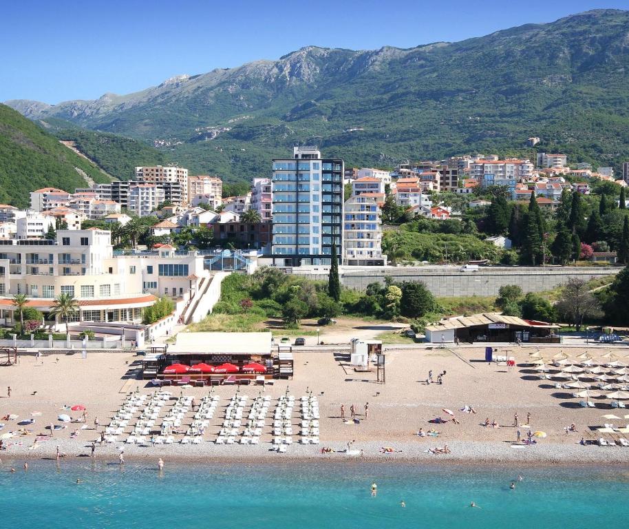 a beach with umbrellas and people on the beach at Shine residence in Budva