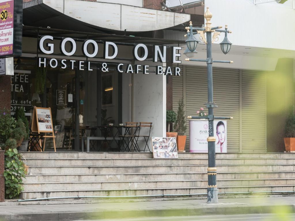 una luz de la calle frente a un hotel y un bar cafetería en Good One Poshtel & Cafe Bar, en Bangkok