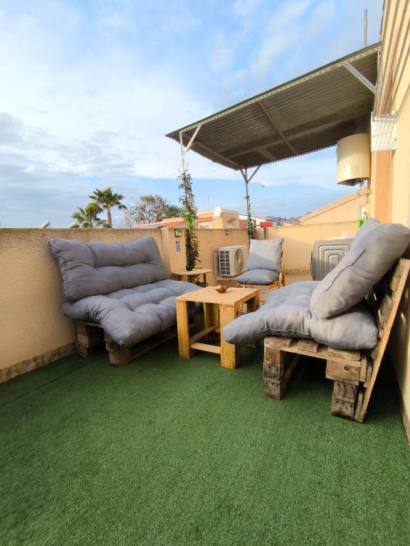 a patio with two couches and a table with a table at El Rincón de Playasol in Puerto de Mazarrón