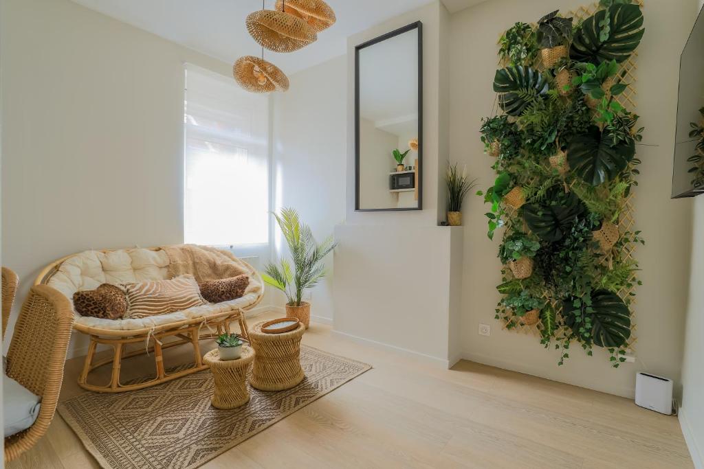 a living room with a couch and plants on the wall at La Canopée - Bohemian - chic apartment in Lens
