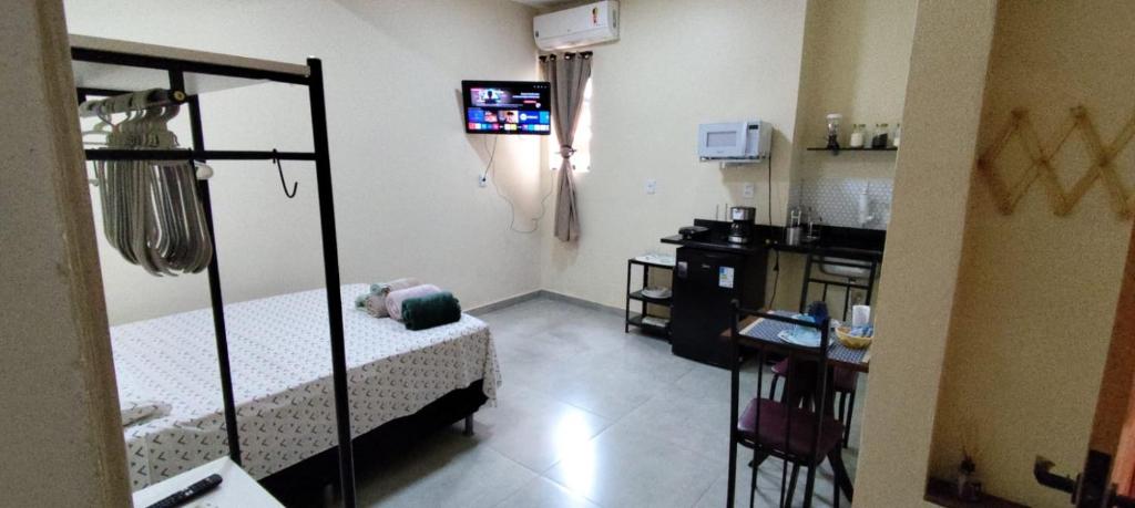 a small room with a bed and a television at Studio Figueira, Flor in Santarém