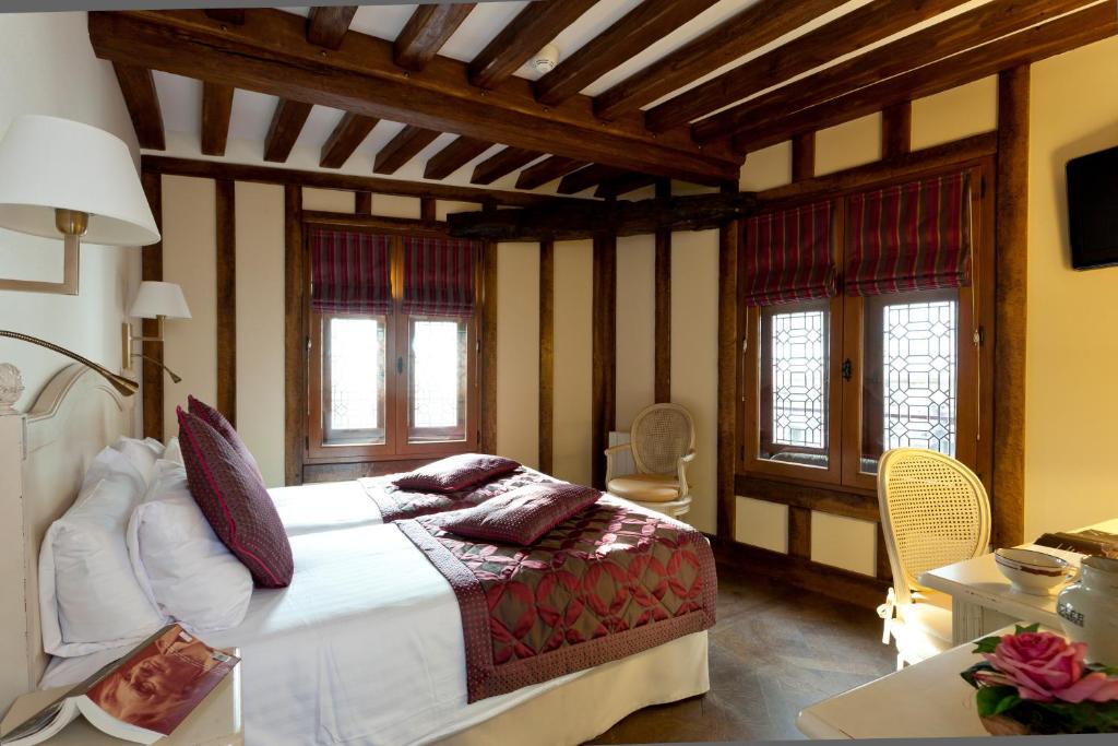 a bedroom with a large bed in a room with windows at Auberge Saint Pierre in Le Mont Saint Michel