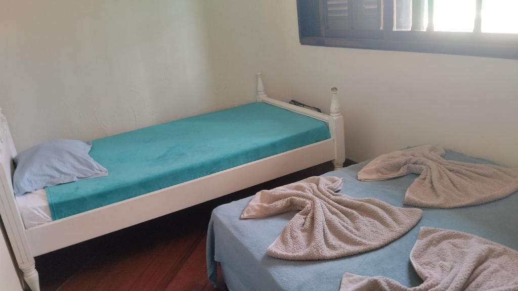 two beds in a room with towels on them at Quarto IV V VI in Curitiba