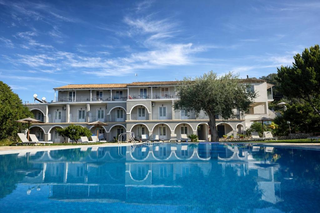 a large building with a large swimming pool at Adriolos Apartments in Liapades