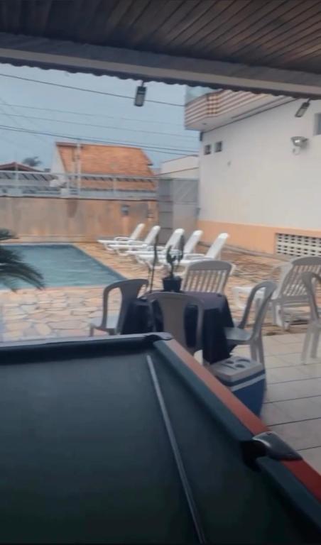a group of chairs and a swimming pool at Residêncial Allah in Peruíbe