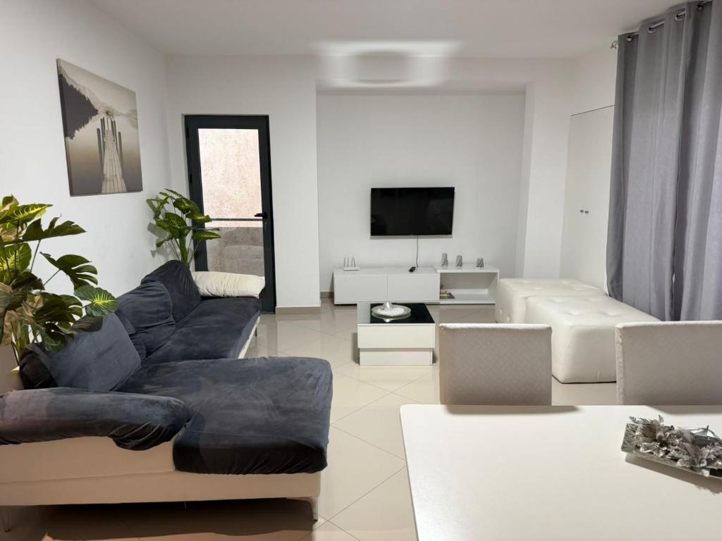 una sala de estar con un sofá y un televisor en Morabeza, en Praia