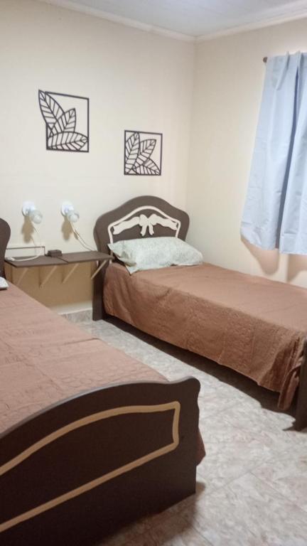 a bedroom with two beds and a window at Altos de la Villa House in Concepción del Uruguay