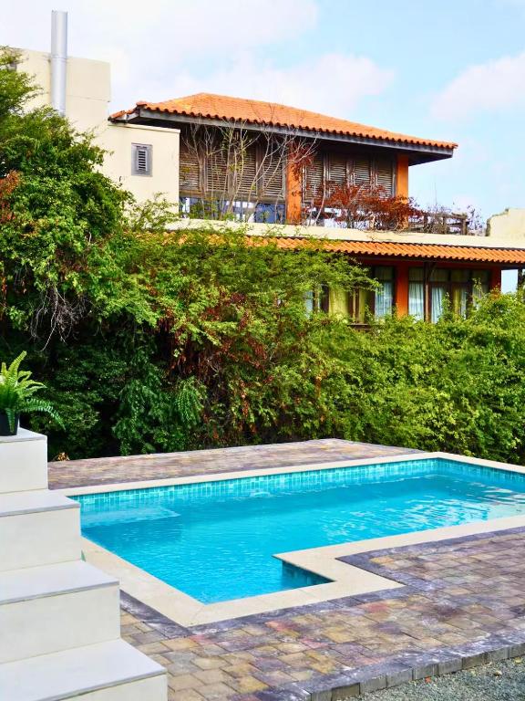 a swimming pool in front of a house at Santirome Studio 2 - Cozy Westpunt Escape for Two in Westpunt