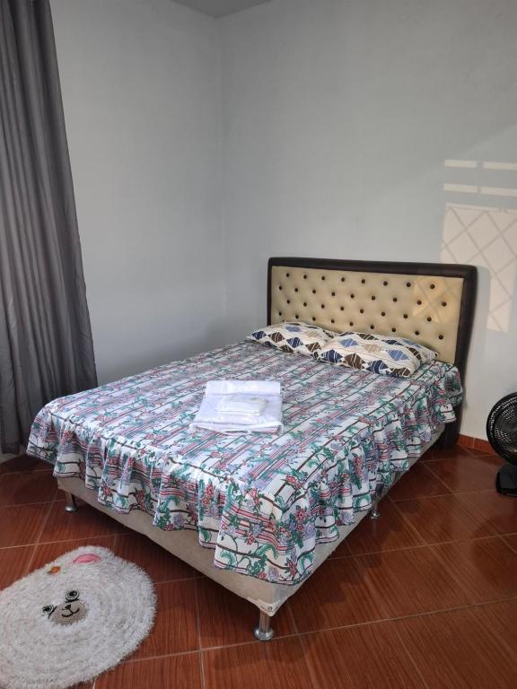 a bed with a quilt on it in a bedroom at Confort Suite 01 in Contagem