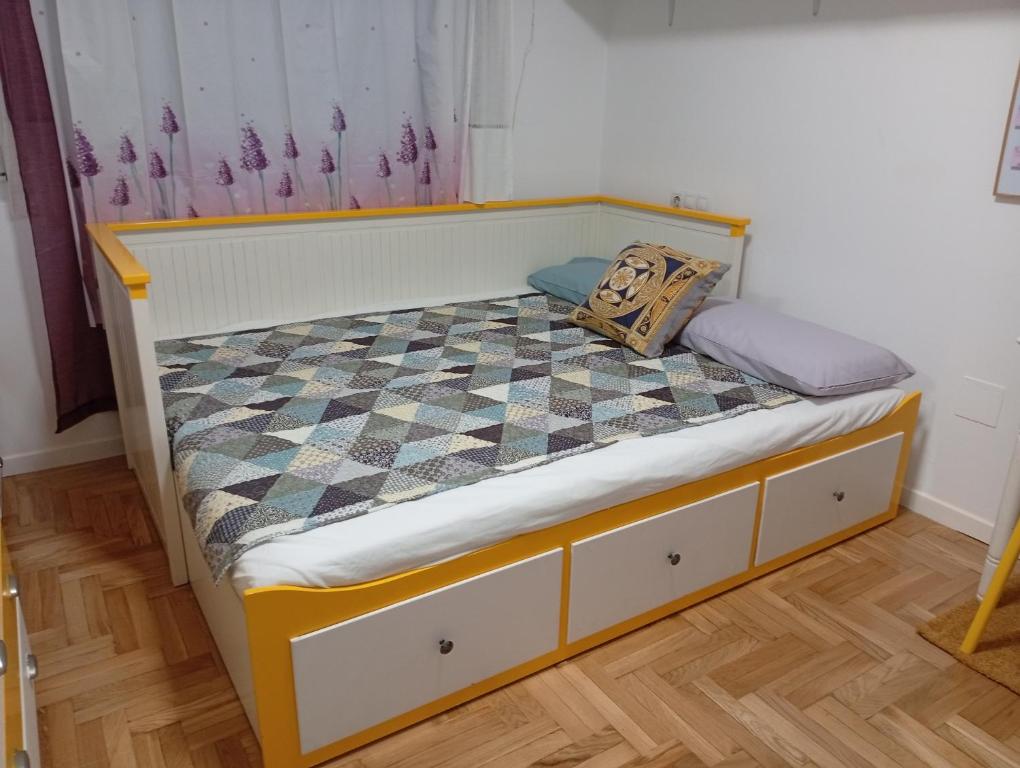 a small bed in a room with a checkered floor at Ka'Luzy in Santa Ana