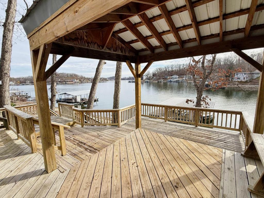 a wooden deck with benches and a view of the water at Fox's Den Your Lakefront Escape with Dock and Stunning Views in Rocky Mount