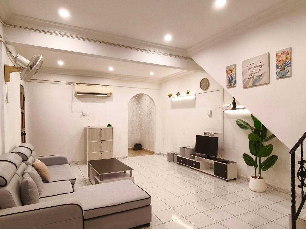 a living room with a couch and a tv at Pasadena Home in Tawau