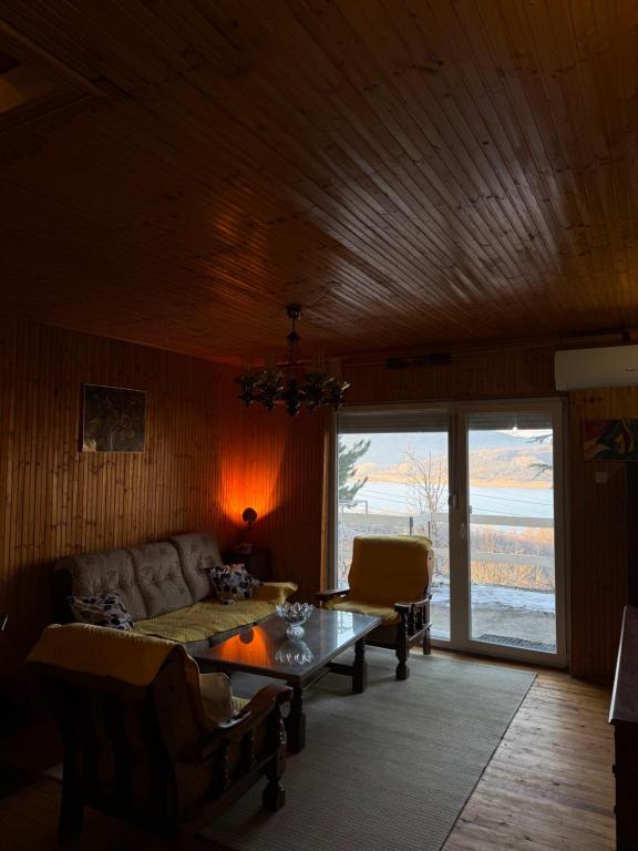 a living room with a couch and a table at Mavrovo Lake Chalet in Mavrovo