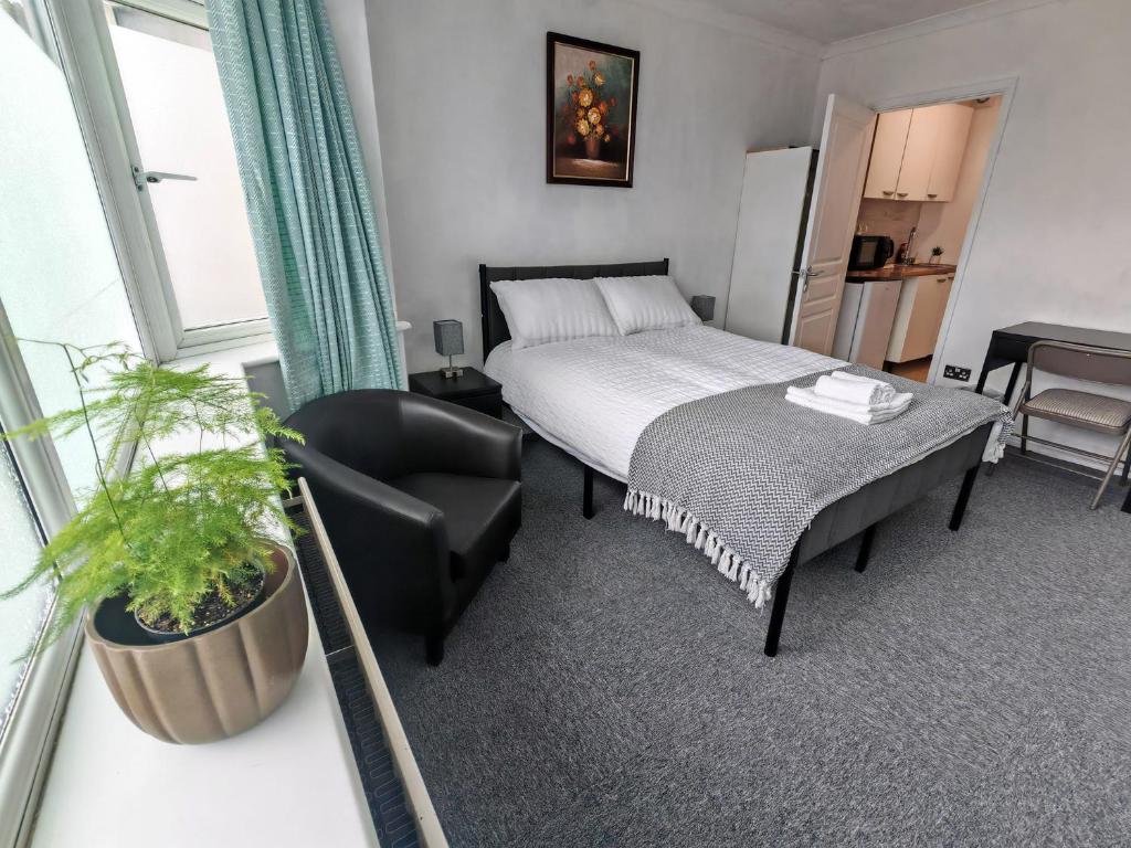 a hotel room with a bed and a chair at Lilac Studio - Self Contained One-Bed Studio Flat in Oxford