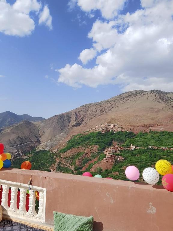 a bunch of balloons sitting on a ledge with a mountain at Azadne in Oulad Akkou