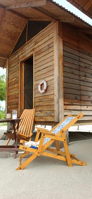 a chair and a table in front of a cabin at Chacahua Cabañas LAUD in Guayabas