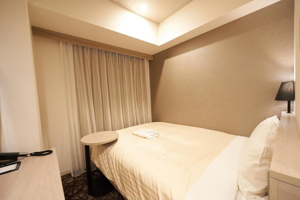 Postel nebo postele na pokoji v ubytování Sotetsu Fresa Inn Ginza-Nanachome