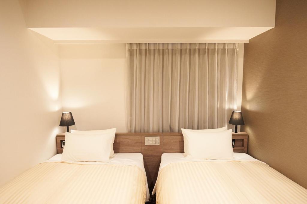 Postel nebo postele na pokoji v ubytování Sotetsu Fresa Inn Ginza-Nanachome