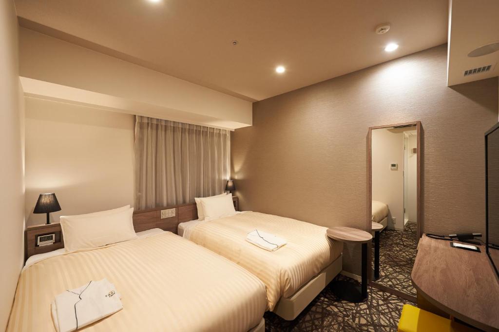 Postel nebo postele na pokoji v ubytování Sotetsu Fresa Inn Ginza-Nanachome