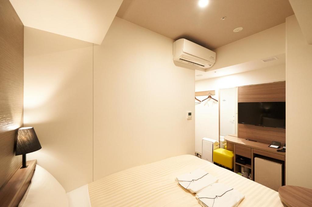 Postel nebo postele na pokoji v ubytování Sotetsu Fresa Inn Ginza-Nanachome