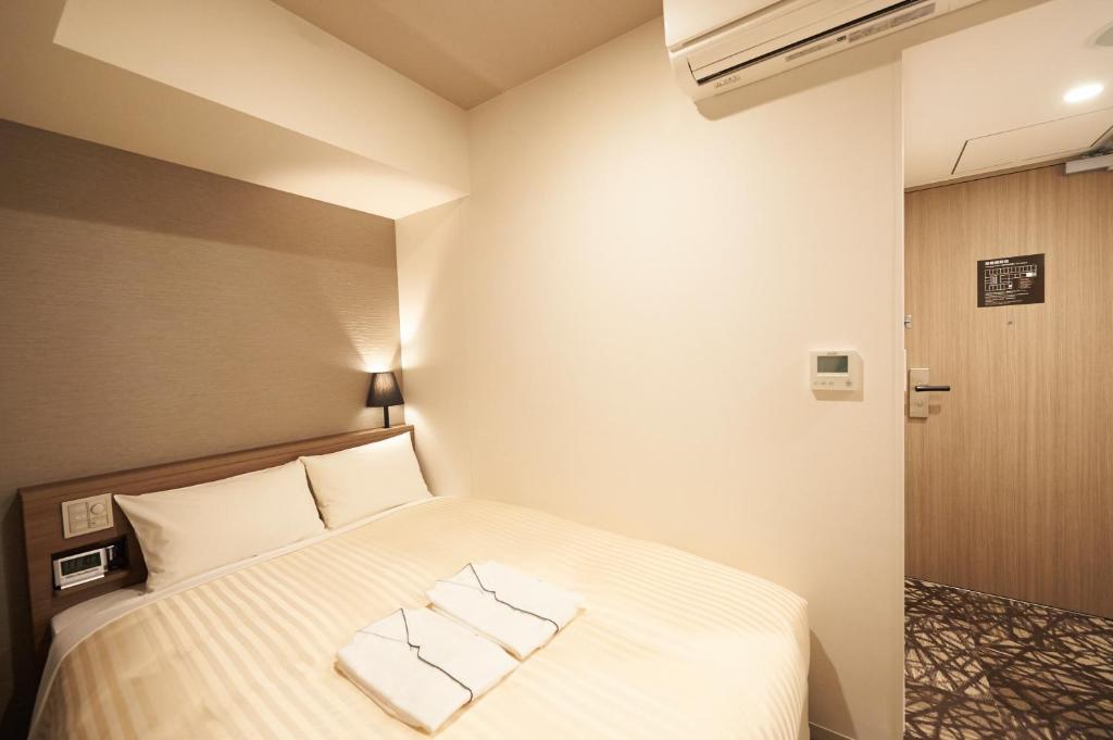 Postel nebo postele na pokoji v ubytování Sotetsu Fresa Inn Ginza-Nanachome